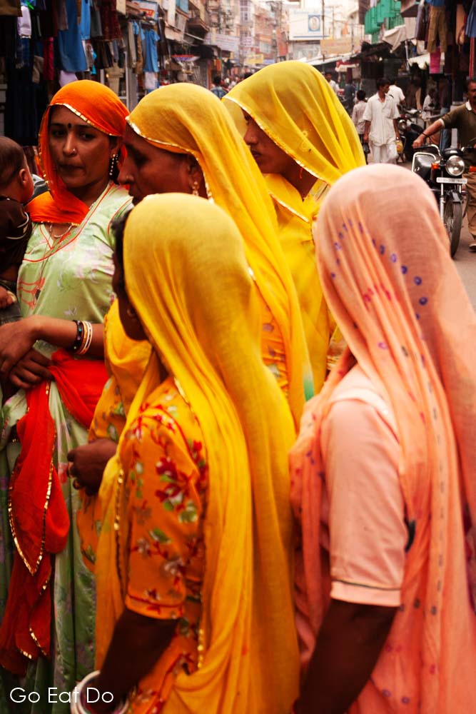 Women in brightly coloured dresses at Nai Sarak in Jodhpur, India.
