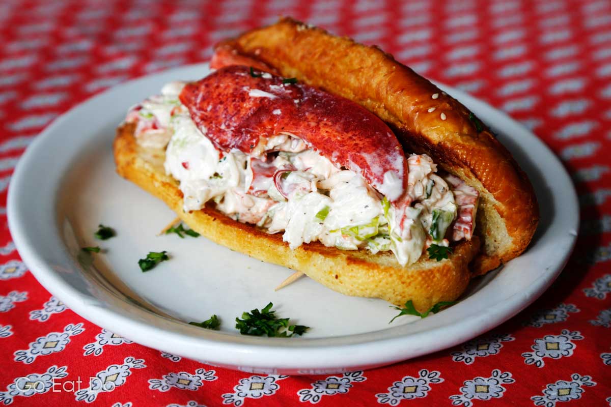 A lobster roll served topped with the meat from a claw.