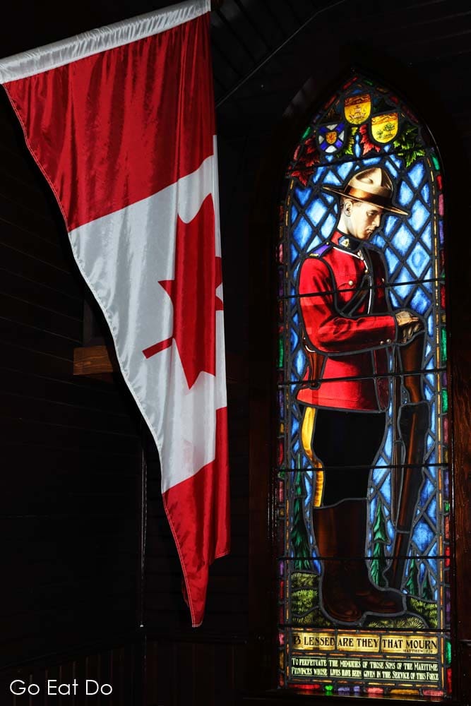 The flag of Canada by a stained glass window in the chapel at the Royal Canadian Mounted Police (RCMP) Depot in Regina, Saskatchewan.