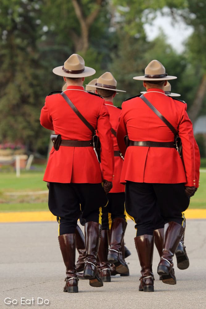 Members of the Royal Canadian Mounted Police marching in red serge uniforms during the Sunset Retreat Ceremony at the RCMP Depot in Regina, Saskatchewan.