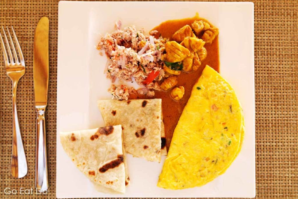 A plate with the traditional Maldivian dish of mas huni, mild chicken curry and roshi flat bread plus an omelette