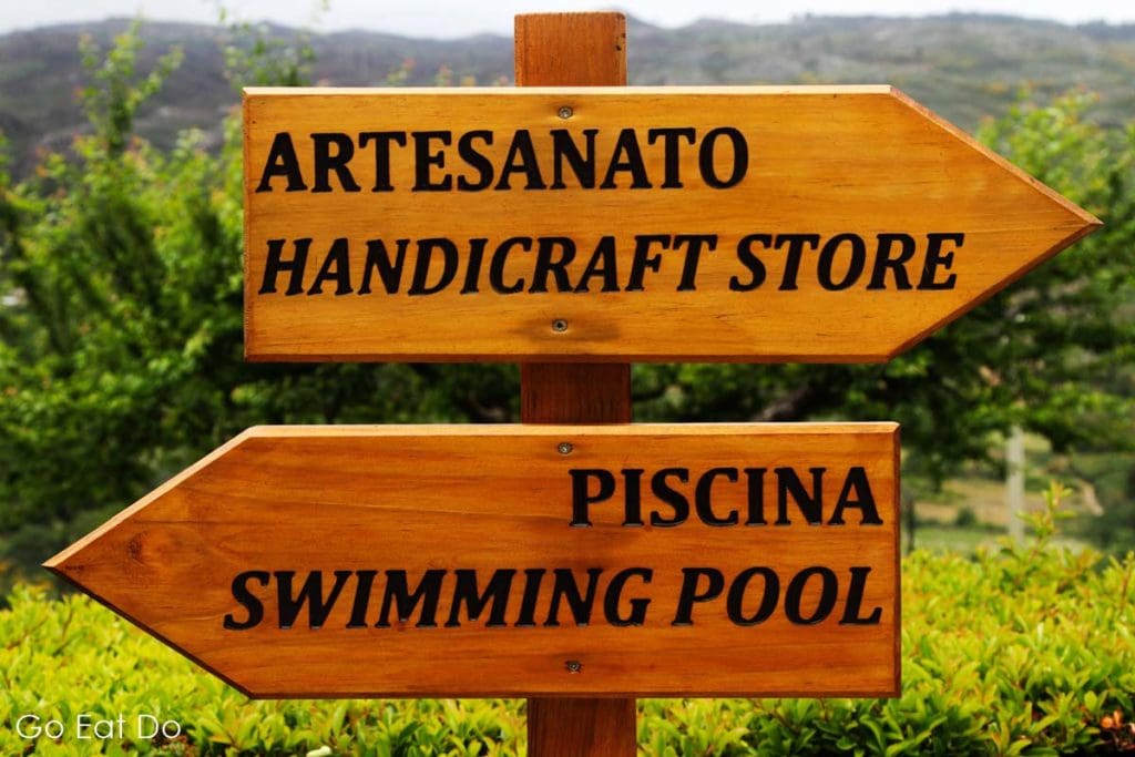 Bilingual signs the handicraft store and swimming pool at the Quinta da Timpeira in the Douro Valley, Portugal