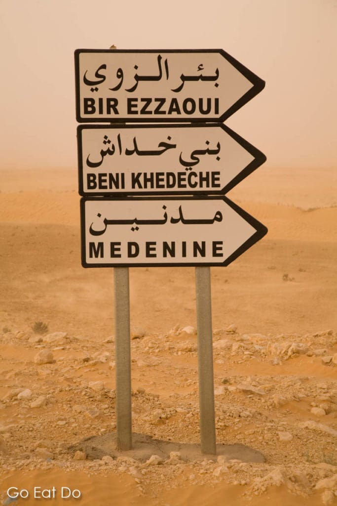 Signpost in the Sahara Desert pointing to destinations in Tunisia