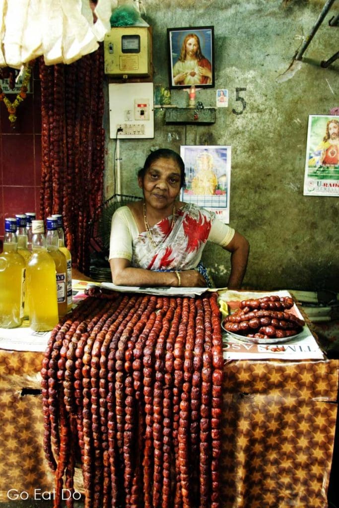 Woman sells locally produced Indian delicacies, including Goan sausage, at the Municipal Market in Margao, Goa.