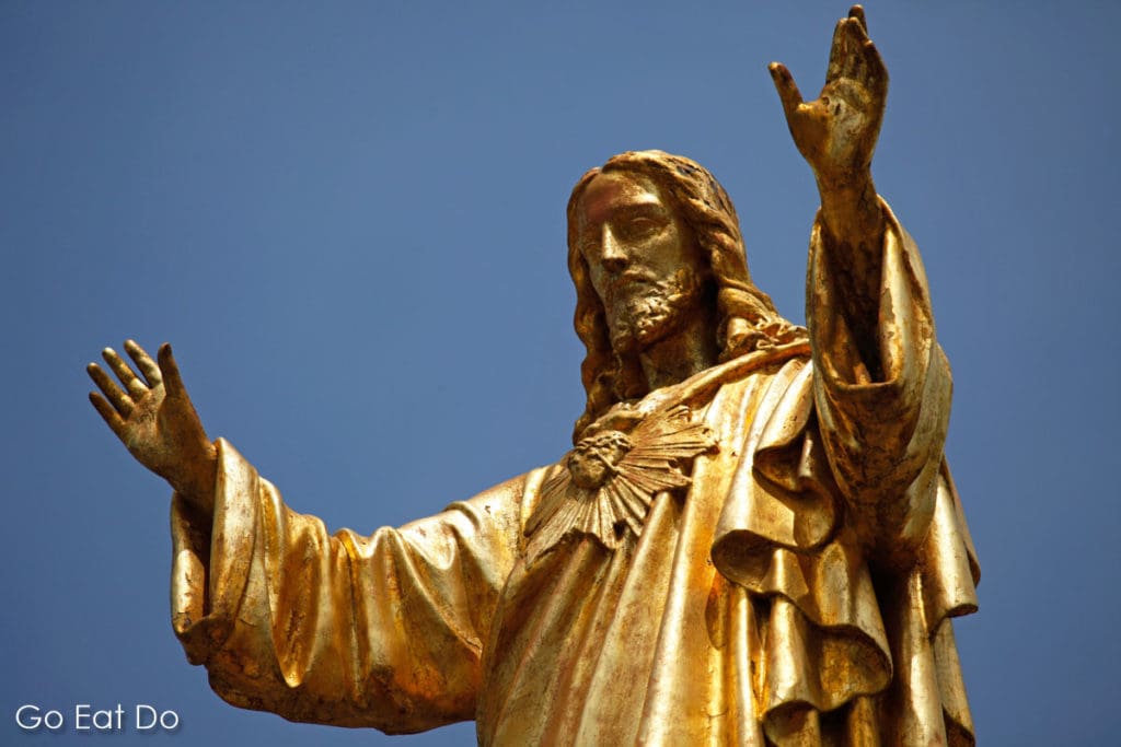 Golden statue of Jesus Christ with arms outstretched in Fatima, Portugal.