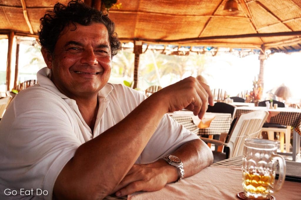 Indian man enjoying a cold beer at a restaurant in Goa, India
