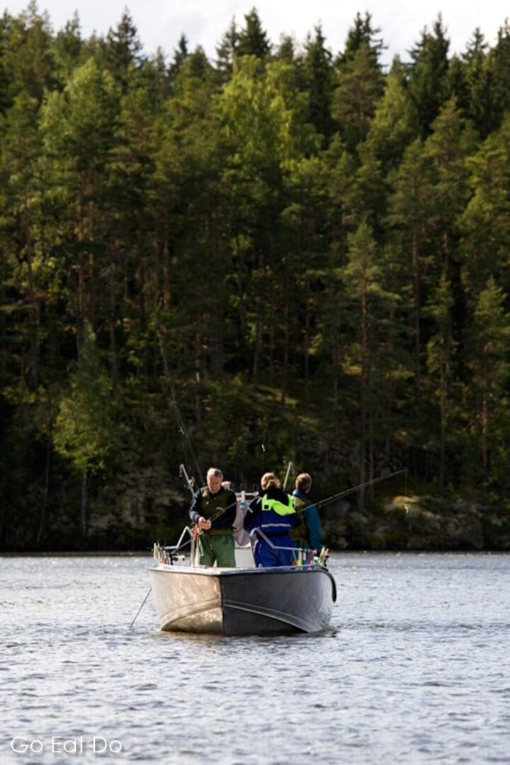 People angling from a boat near Tampere. Fishing is one of the key reasons to visit Tampere for many travellers.