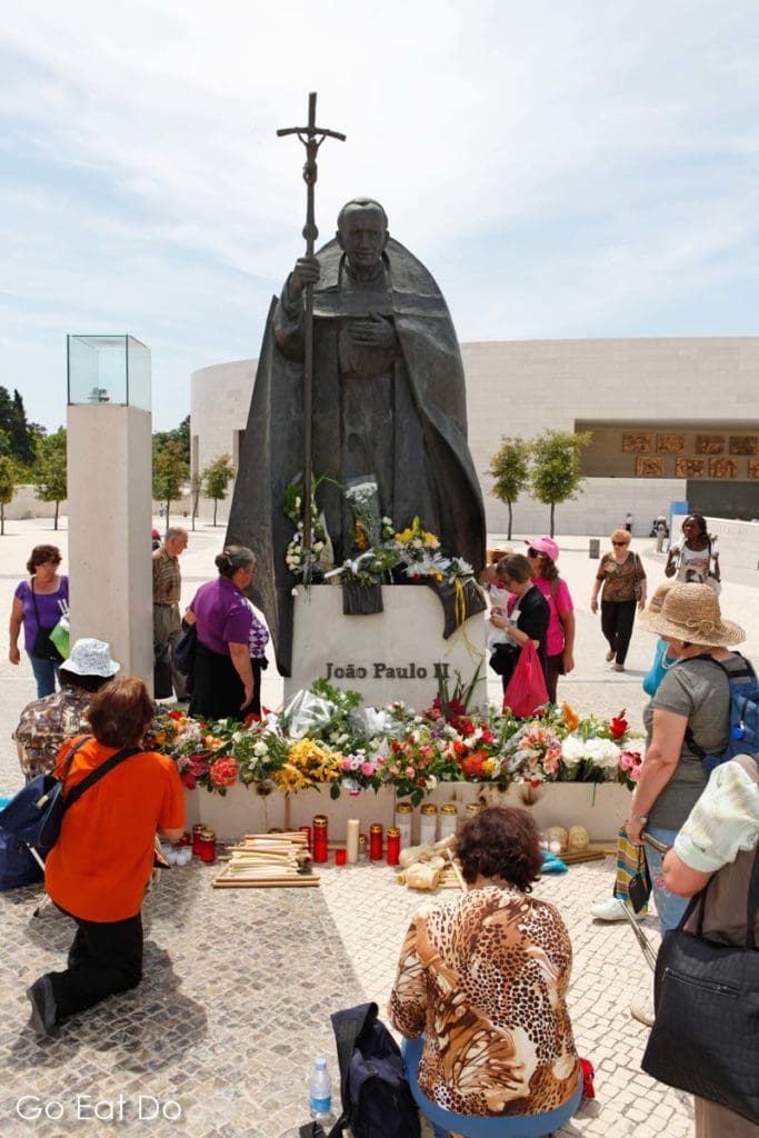 Christians pray by the statue of Pope John Paul II in Fatima, Portugal, on the Feast of Our Lady of the Blessed Sacrament on 13 May 2011.