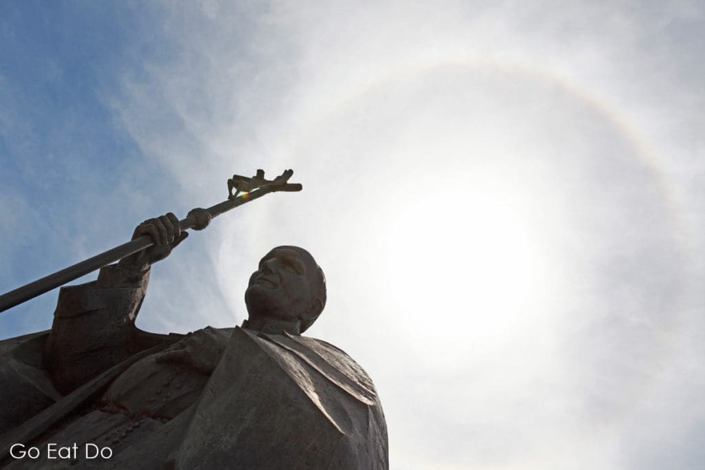 Solar halo or miracle of the sun in Fatima, Portugal? The phenomenon appears above a sculpture of Pope John Paul II.