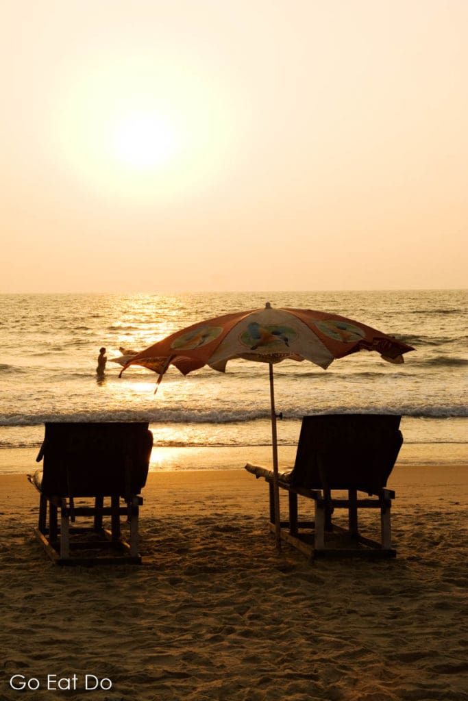 Sun loungers looks towards the Arabian Sea as the sun sets on a beach in Goa, India.