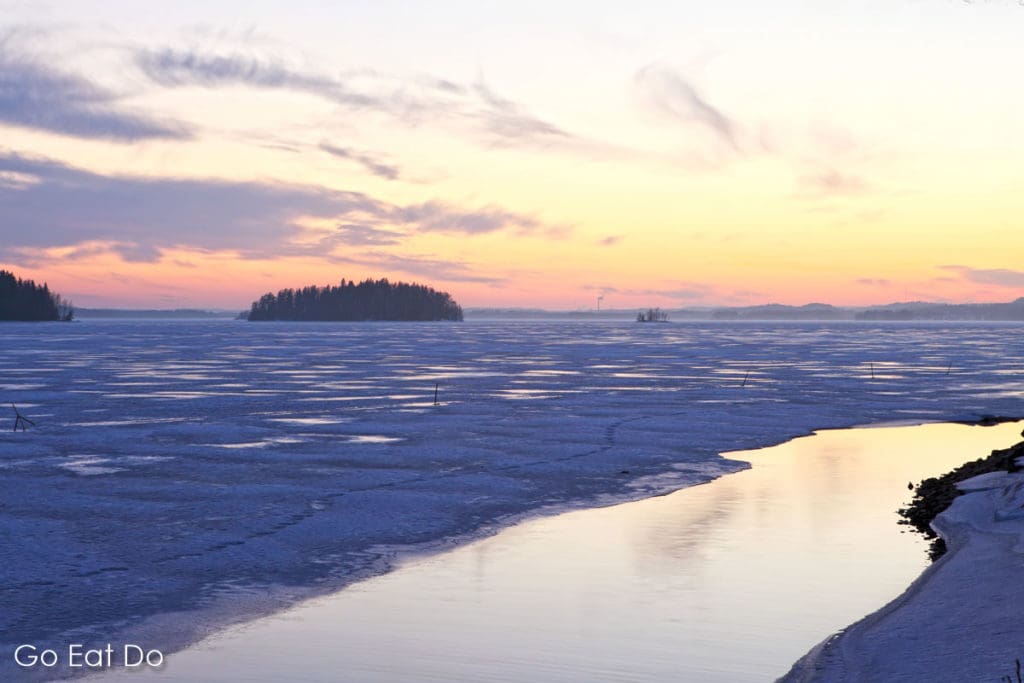 Winter sunset over the mainly frozen surface of Lake Pyhajarvi on the outskirts of Tampere in Finland.