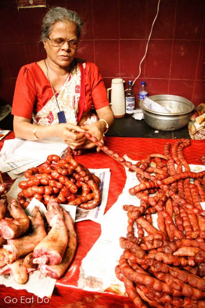 Woman selling Goan sausage at the Municipal Market in Margao, Goa.