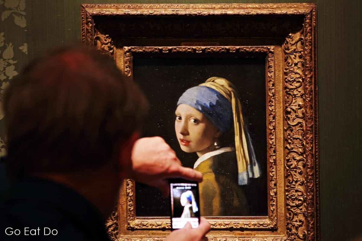 A visitor photographs Vermeer's Girl with a Pearl Earring at the Mauritshuis in The Hague