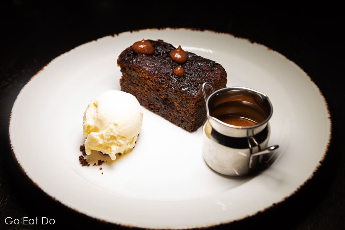 Sticky toffee pudding served with ice cream and caramel sauce.