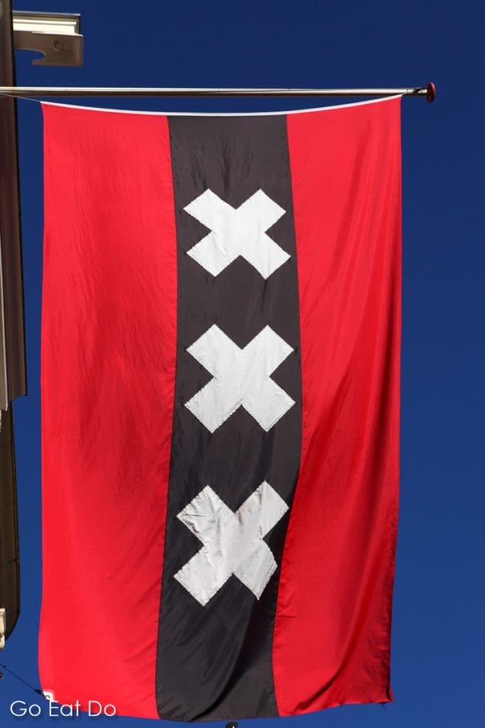 The red and black flag of Amsterdam bearing three white crosses.