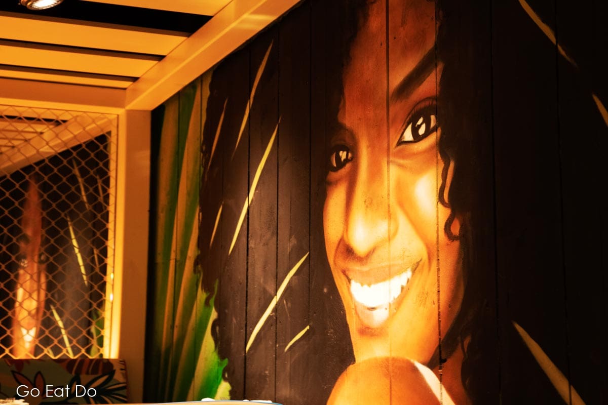 Mural depicting a smiling woman at the Turtle Bay Durham restaurant.