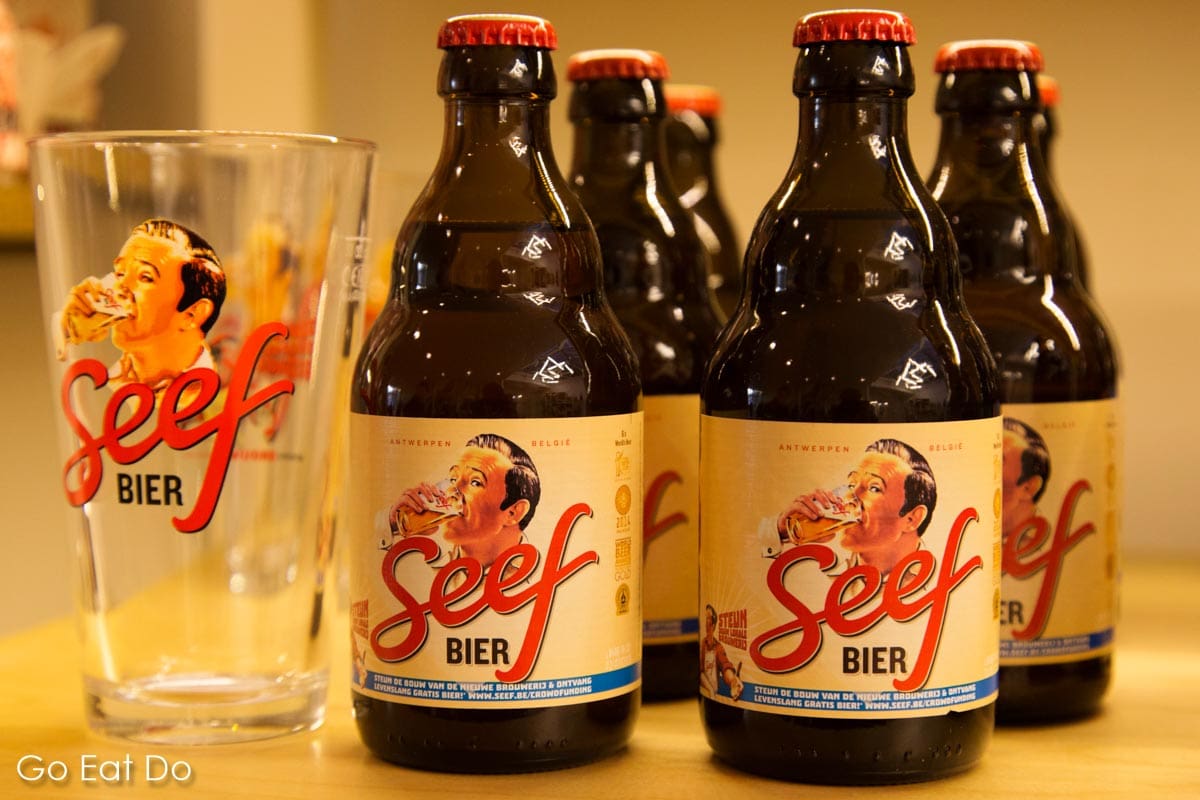 Bottles of Seef beer, seefbier was popular before World War One and relaunched in the 21st century and a glass bearing the logo of the Belgian beer.