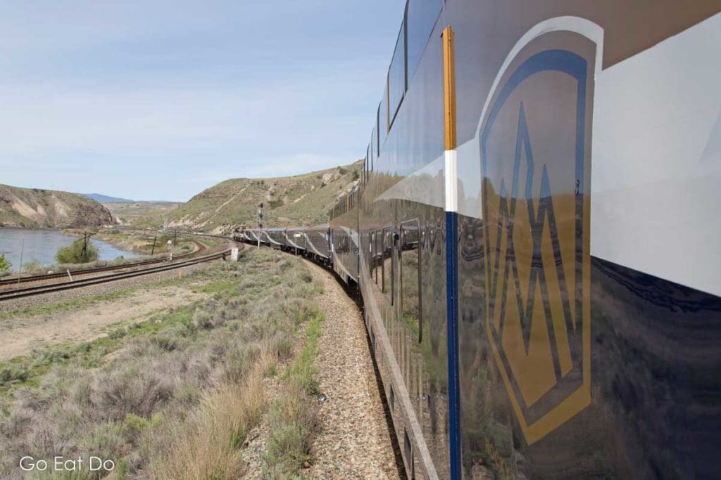Logo of the Rocky Mountaineer on the side of the train during a scenic journey in British Columbia.