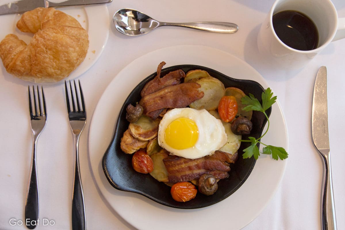 A breakfast skillet served with a croissant and coffee in the Rocky Mountaineer's GolfLeaf Service dining carriage.