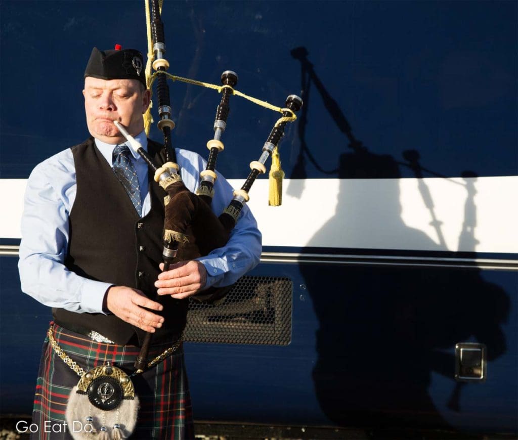 A piper pipes a welcome for guests onto the Rocky Mountaineer train at its Vancouver station.