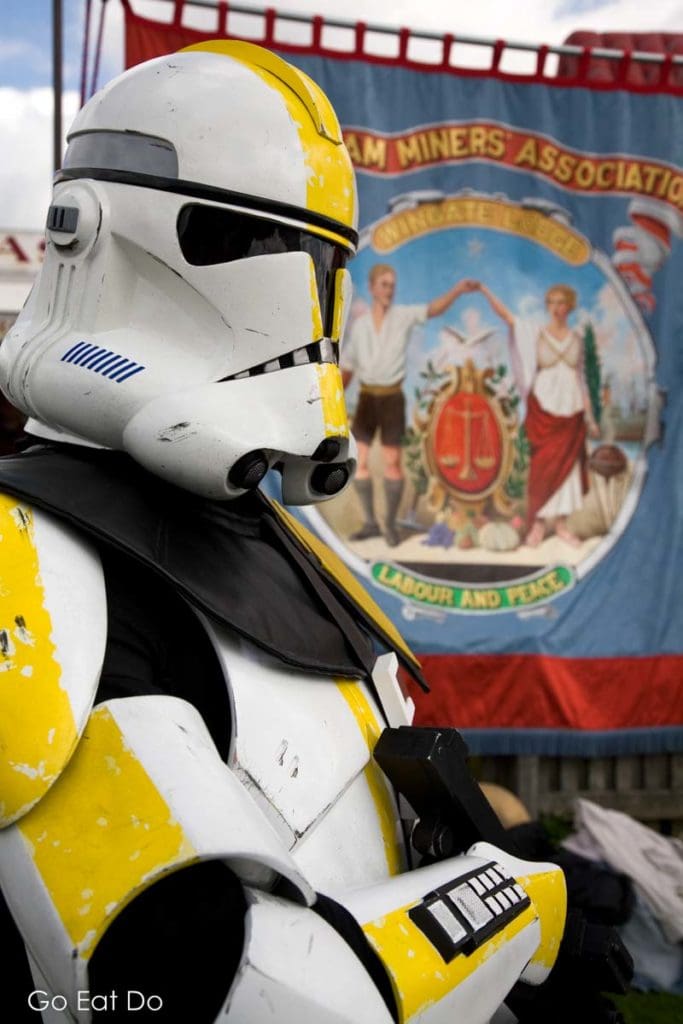 Person dressed as a Star Wars Imperial Stormtrooper by a union banner during the Big Meeting in Durham City