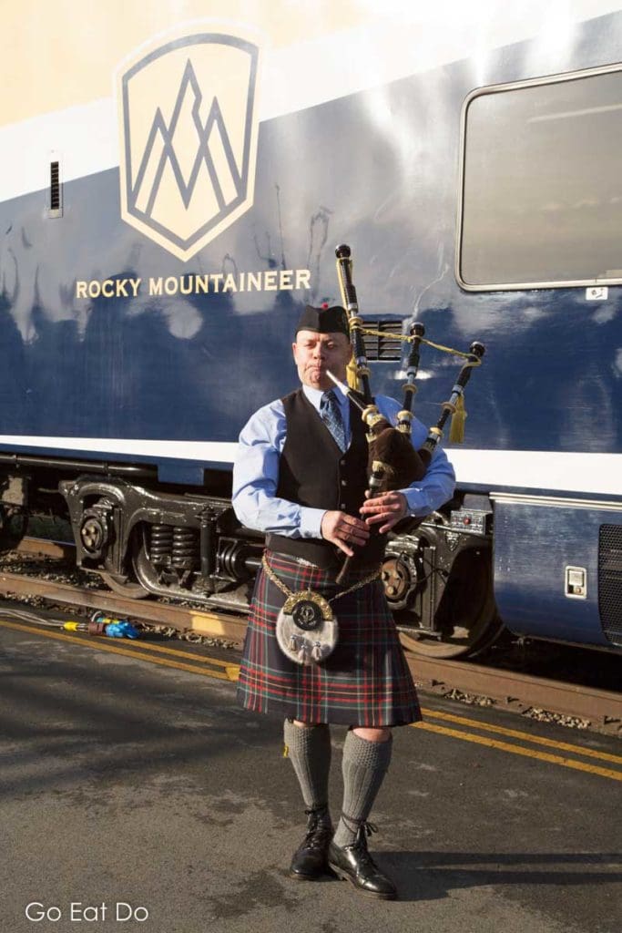 Bagpiper piping travellers aboard the Rocky Mountaineer train in Canada.