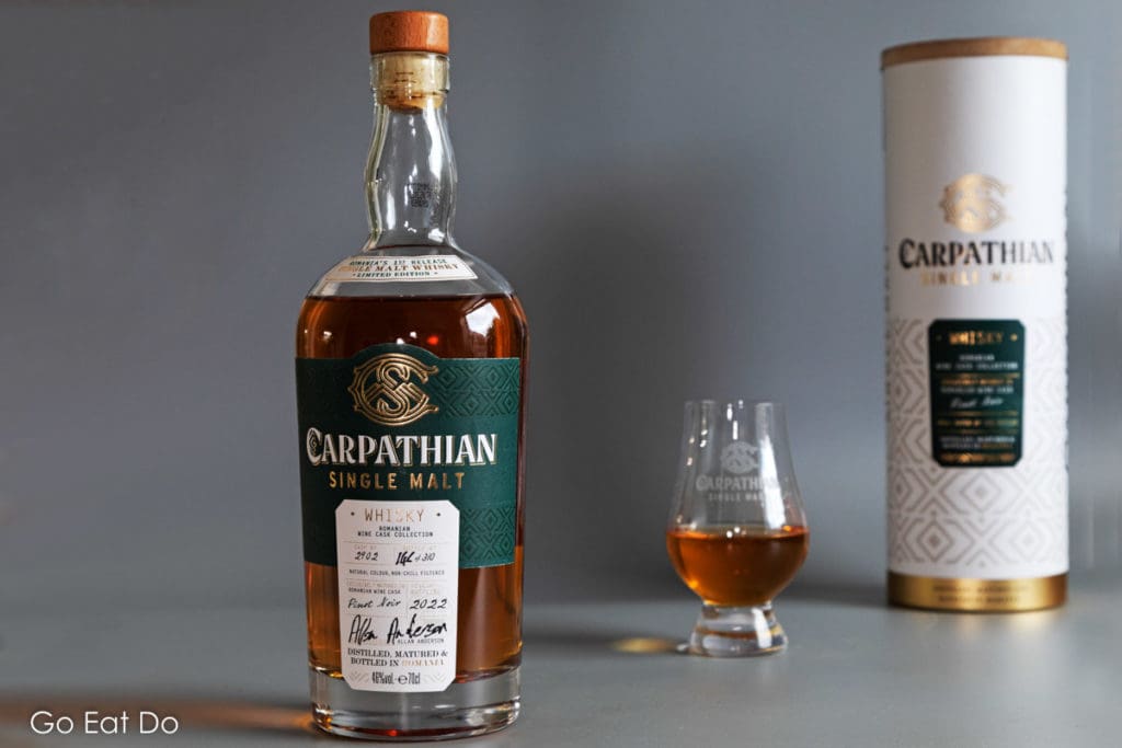 A bottle, glass and presentation pack of Carpathian Single Malt whisky.