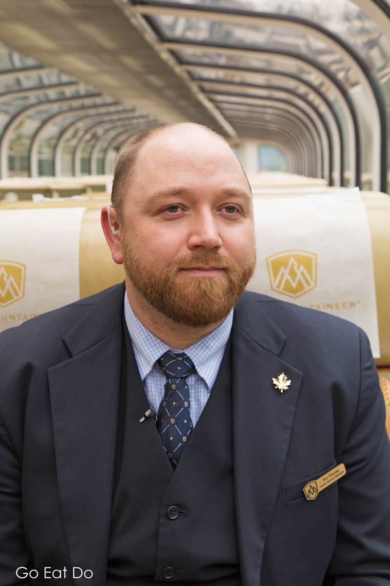 Guest Service Manager Ira Young sitting in GoldLeaf Service seating on the Rocky Mountaineer luxury train in western Canada.