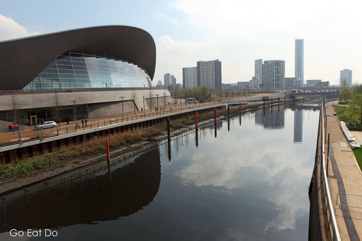 London Aquatics Centre reflecting in the WaterWorks River at Queen Elizabeth Park in London, England.