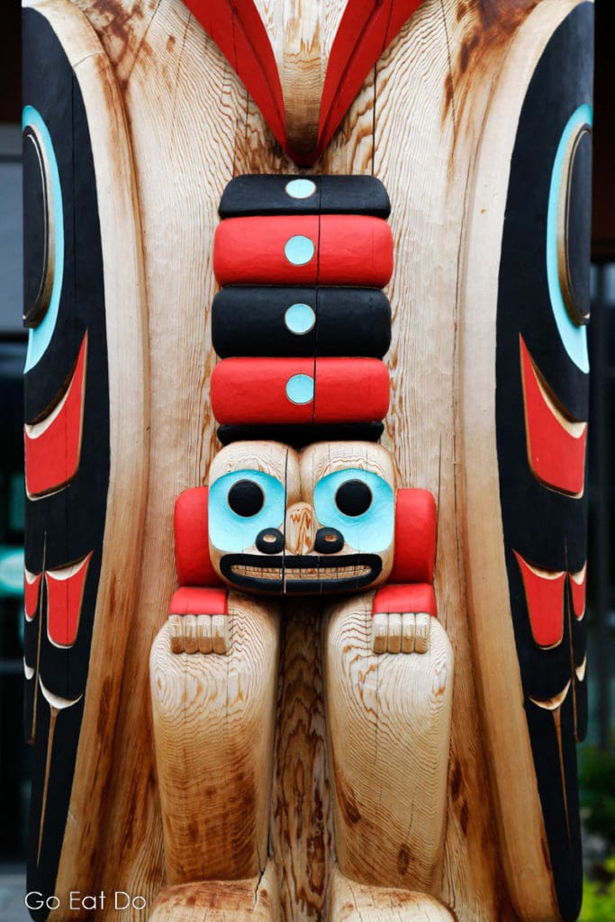 Detail of a colourful First Nations carving charged with symbolic meaning.