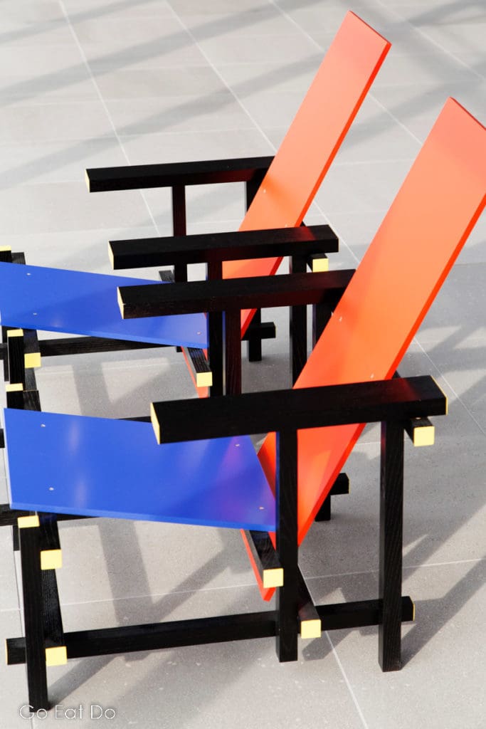 Examples of the Red Blue Chair, designed by Gerrit Rietveld, one of the iconic designs associated with De Stijl.