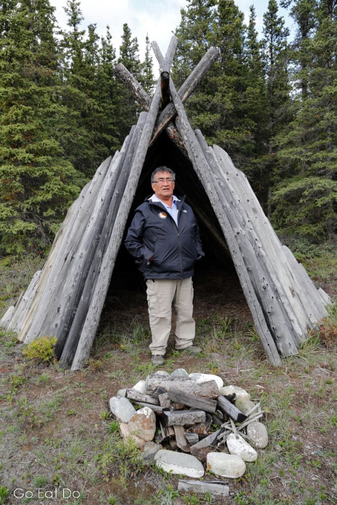 James Allen, a former chief of the Champagne and Aishihik First Nations by a traditionally built shelter.