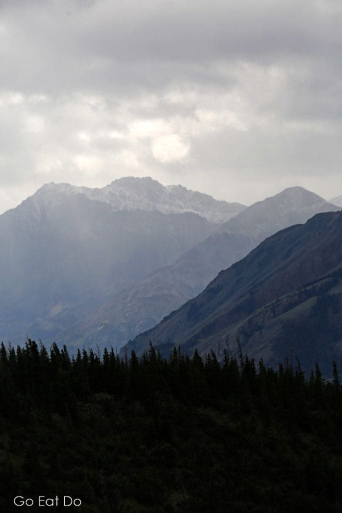 Mountains shrouded by grey clouds on an autumn day in the Yukon, Canada.