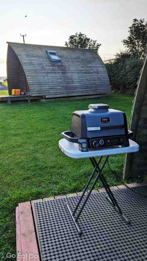 A Ninja Woodfire outdoor grill, the Ninja Woodfire Electric BBQ Grill and Smoker, ready for use while glamping.