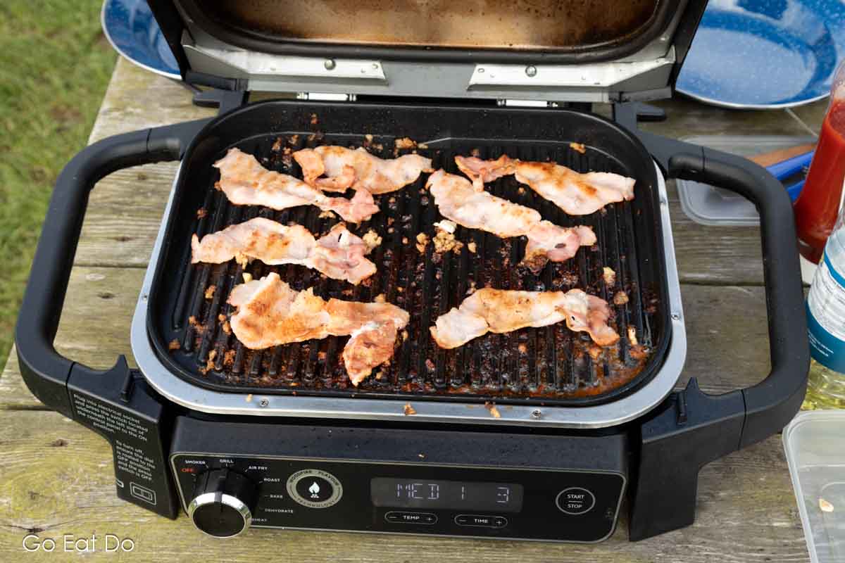 https://go-eat-do.com/wp-content/uploads/2023/09/after-cooking-bacon-i-was-glad-that-the-ninja-woodfire-outdoor-grill-is-easy-to-clean.jpg